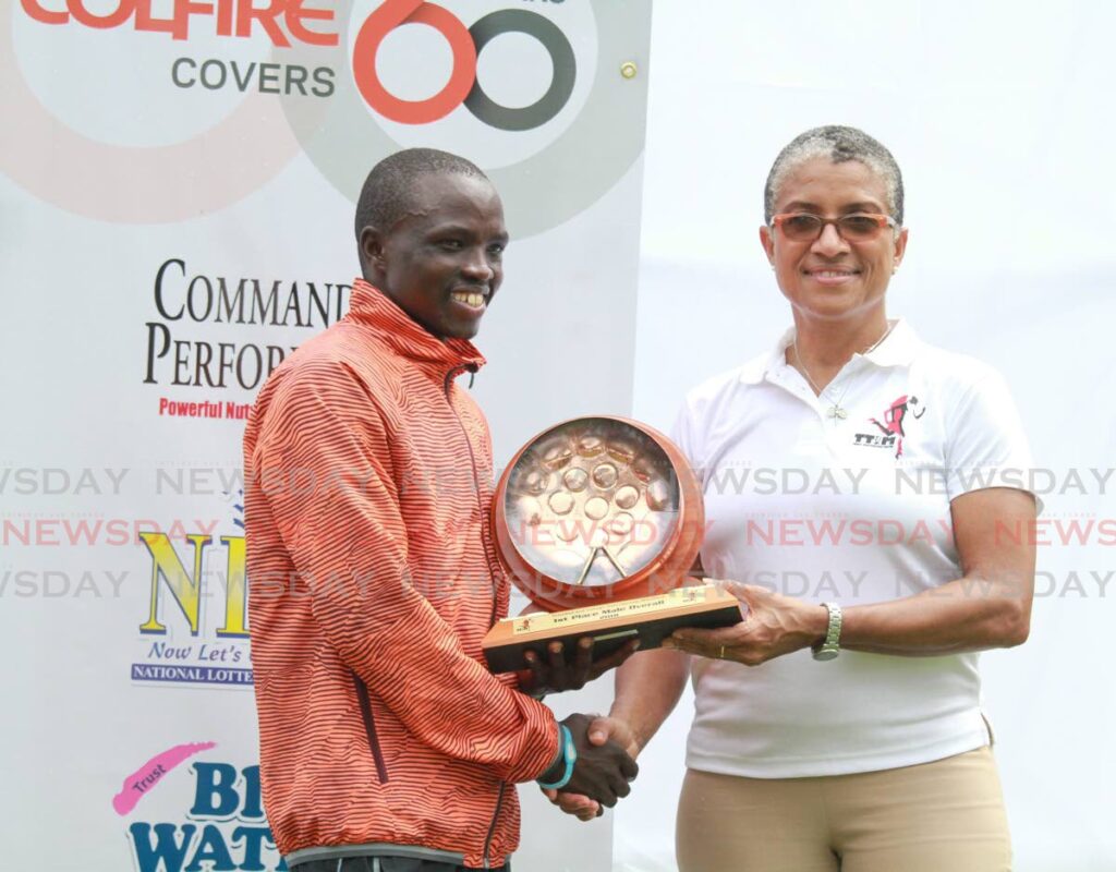Meets & Features : Stephen Mburi Njoroge winner's trophy from Dianne Henderson  TT International Marathon 2018